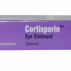 A tube of Cortisporin Eye Ointment placed on a white surface with scattered eye-related medical equipment in the background.
